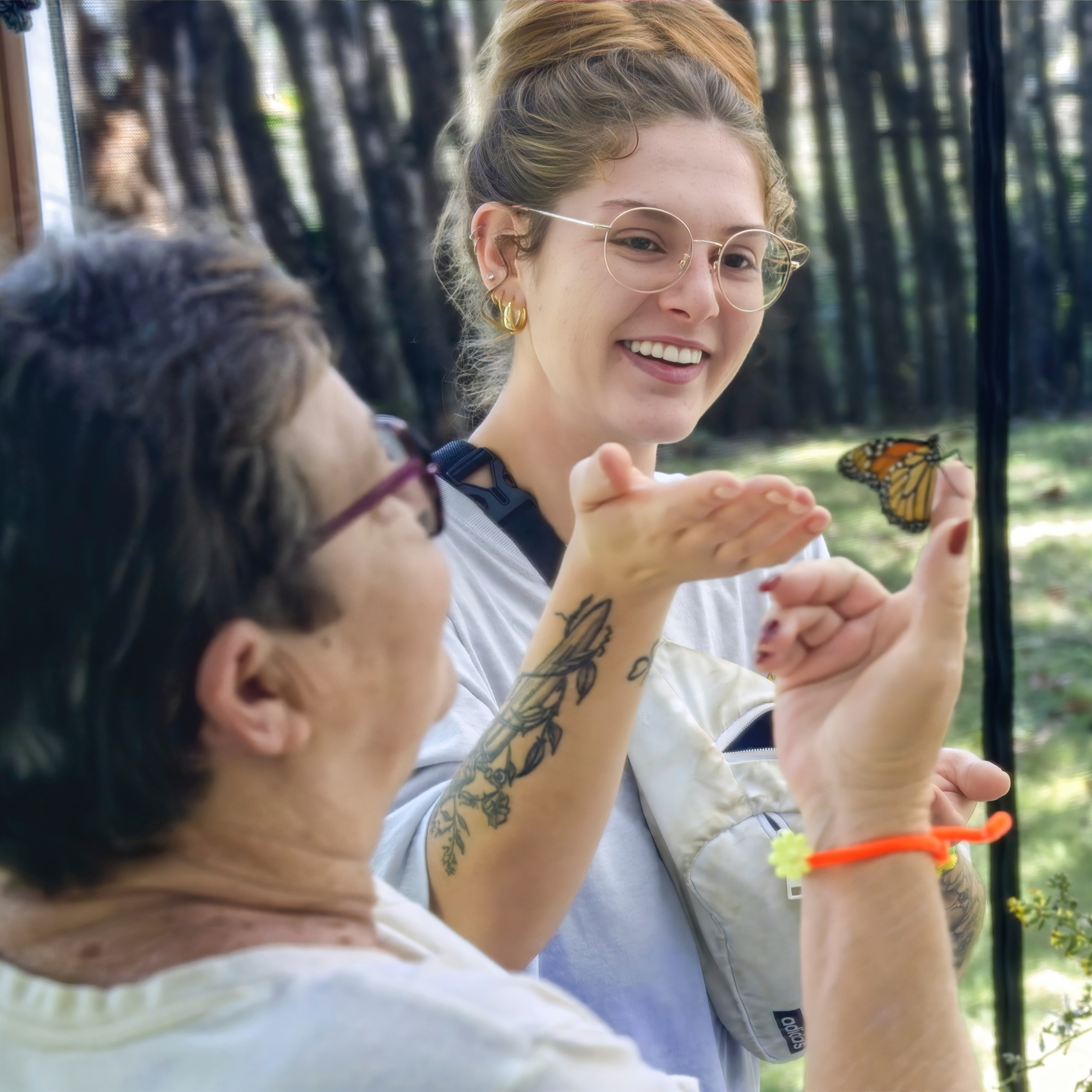 Two women gazing at a butterfly